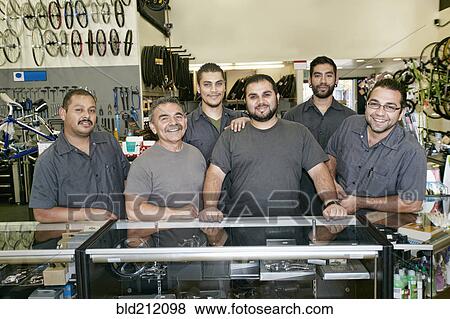 Stock Photo - Mechanics smiling in bicycle repair shop. Fotosearch