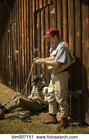 Men adjusting fishing rods View Large Photo Image Stock Image - Men adjusting fishing rods. Fotosearch