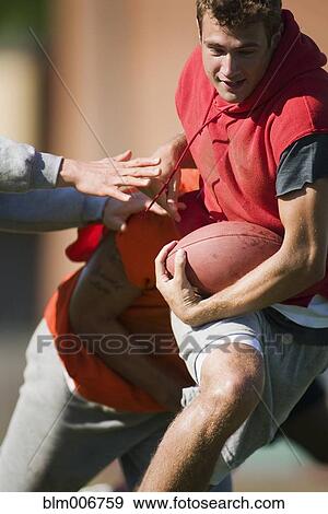Stock Photo - Men playing football. Fotosearch