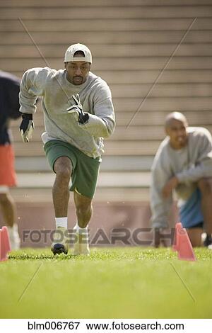 Men training on football field View Large Photo Image Stock Photo - Men training on football field. Fotosearch