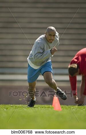 Stock Photo - Men training on football field. Fotosearch