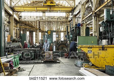 Stock Image - Men working in metal shop. Fotosearch