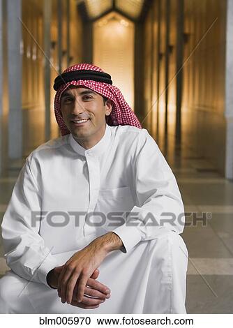 Middle Eastern man in traditional clothing squatting in hallway View Large Photo Image Stock Image - Middle Eastern man in traditional clothing squatting in hallway. Fotosearch