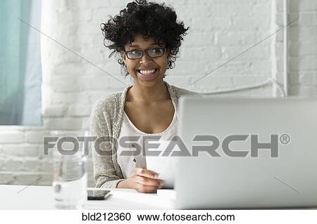 Stock Image - Mixed race architect working at desk. Fotosearch