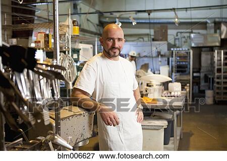Mixed race bakery owner standing in kitchen View Large Photo Image Stock Photo - Mixed race bakery owner standing in kitchen. Fotosearch