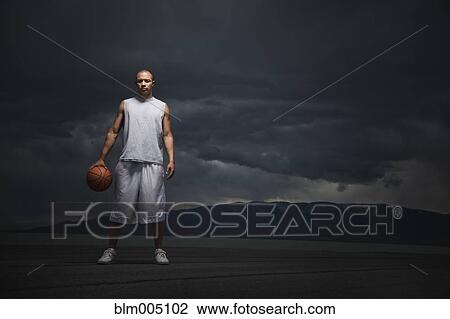 Mixed race basketball player standing with storm clouds in distance View Large Photo Image Stock Image - Mixed race basketball player standing with storm clouds in distance. Fotosearch