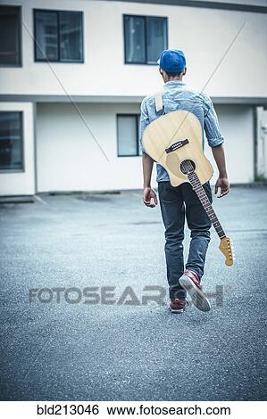 Mixed race boy carrying guitar in parking lot View Large Photo Image Stock Photograph - Mixed race boy carrying guitar in parking lot. Fotosearch