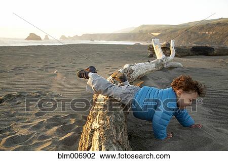 Mixed race boy crawling on beach View Large Photo Image Stock Image - Mixed race boy crawling on beach. Fotosearch