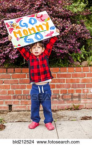 Picture - Mixed race boy holding Go mommy go sign. Fotosearch