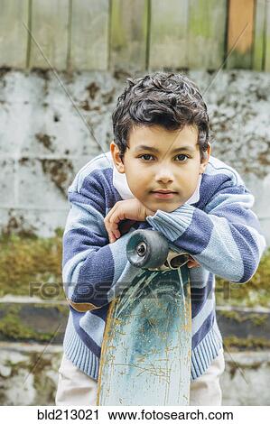 Mixed race boy leaning on skateboard outdoors View Large Photo Image Stock Image - Mixed race boy leaning on skateboard outdoors. Fotosearch