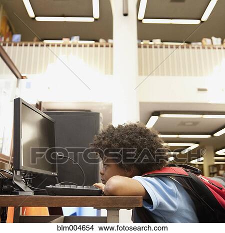 Mixed race boy looking at computer monitor View Large Photo Image Picture - Mixed race boy looking at computer monitor. Fotosearch