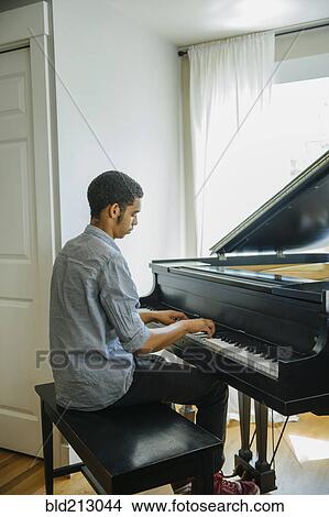 Picture - Mixed race boy playing piano. Fotosearch