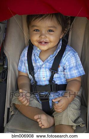 Stock Photo - Mixed race boy sitting in stroller. Fotosearch