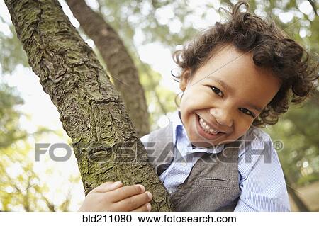 Stock Image - Mixed race boy smiling in park. Fotosearch