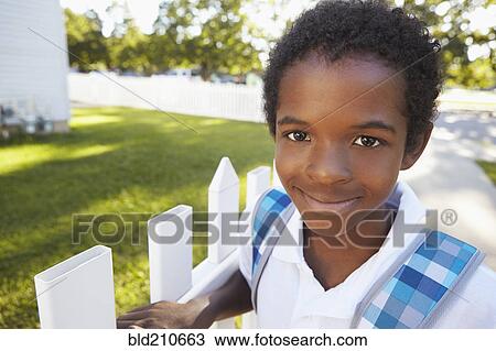 Stock Image - Mixed race boy smiling on suburban street. Fotosearch