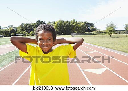 Stock Photo - Mixed race boy smiling on track. Fotosearch