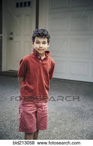 Stock Photo - Mixed race boy standing on driveway. Fotosearch