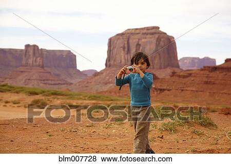 Mixed race boy taking pictures in Monument Valley View Large Photo Image Stock Photo - Mixed race boy taking pictures in Monument Valley. Fotosearch