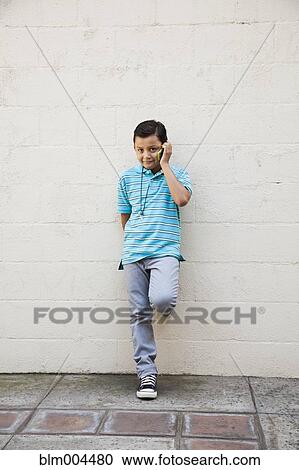 Stock Image - Mixed race boy talking on cell phone. Fotosearch