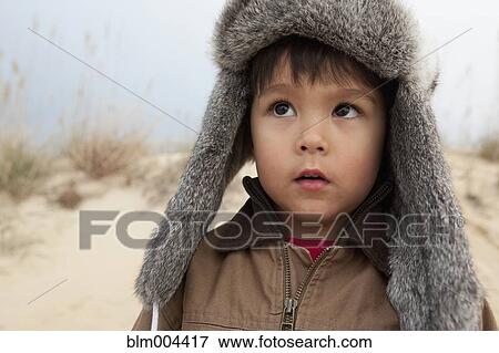 Stock Photo - Mixed race boy wearing fur hat. Fotosearch