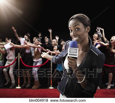 Stock Photo - Mixed race broadcaster at red carpet event. Fotosearch