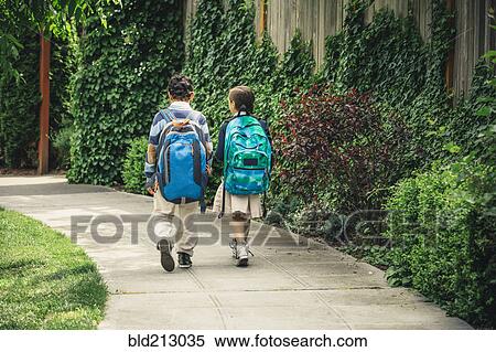 Stock Photography - Mixed race brother and sister walking on sidewalk. Fotosearch