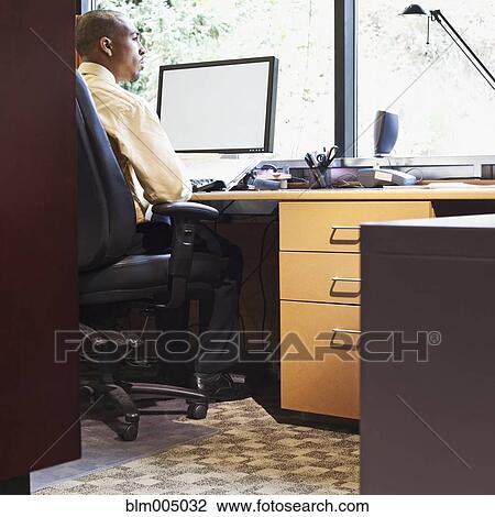 Mixed race businessman daydreaming at desk View Large Photo Image Stock Image - Mixed race businessman daydreaming at desk. Fotosearch