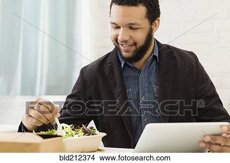 Mixed race businessman eating salad View Large Photo Image Picture - Mixed race businessman eating salad. Fotosearch