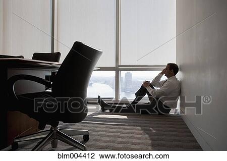 Mixed race businessman sitting on office floor next to window View Large Photo Image Stock Image - Mixed race businessman sitting on office floor next to window. Fotosearch