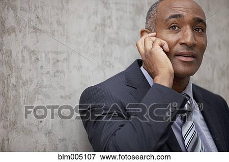 Stock Photo - Mixed race businessman talking on cell phone. Fotosearch