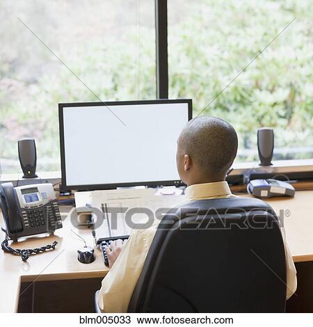 Mixed race businessman working at desk View Large Photo Image Stock Image - Mixed race businessman working at desk. Fotosearch