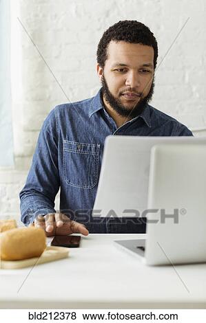 Mixed race businessman working at desk View Large Photo Image Stock Photo - Mixed race businessman working at desk. Fotosearch