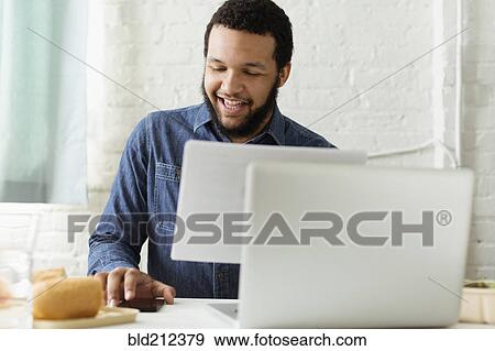 Mixed race businessman working at desk View Large Photo Image Stock Photo - Mixed race businessman working at desk. Fotosearch