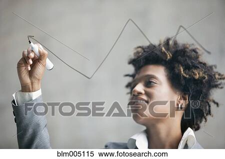 Stock Photography - Mixed race businesswoman drawing on clear board. Fotosearch