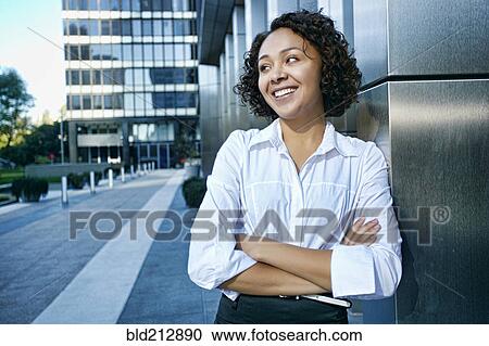 Mixed race businesswoman standing in city View Large Photo Image Stock Image - Mixed race businesswoman standing in city. Fotosearch