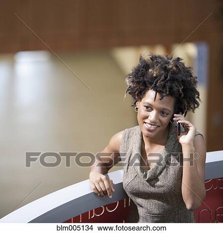 Picture - Mixed race businesswoman talking on cell phone. Fotosearch