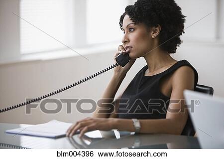 Mixed race businesswoman talking on telephone View Large Photo Image Stock Photograph - Mixed race businesswoman talking on telephone. Fotosearch