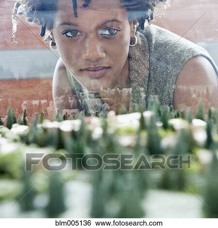 Mixed race businesswoman viewing development model View Large Photo Image Stock Photograph - Mixed race businesswoman viewing development model. Fotosearch
