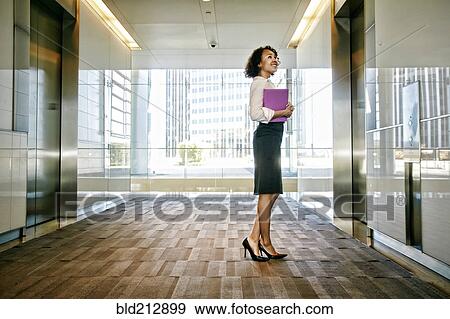 Mixed race businesswoman waiting for elevator in lobby View Large Photo Image Stock Photo - Mixed race businesswoman waiting for elevator in lobby. Fotosearch