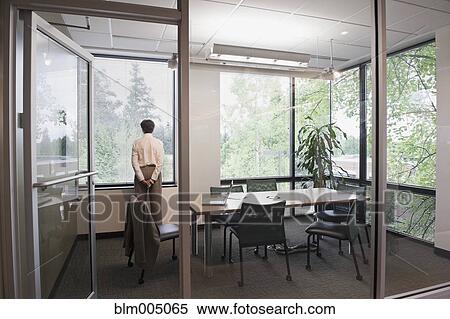 Stock Photography - Mixed race businesswoman waiting in conference room. Fotosearch