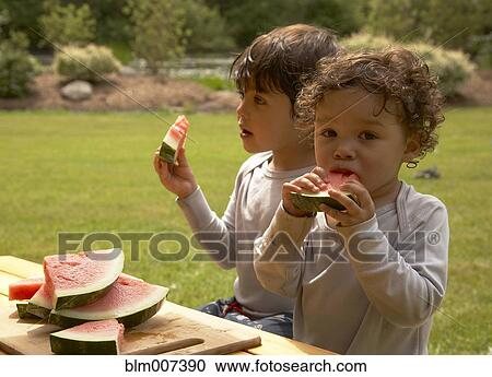 Mixed race children eating watermelon View Large Photo Image Stock Image - Mixed race children eating watermelon. Fotosearch