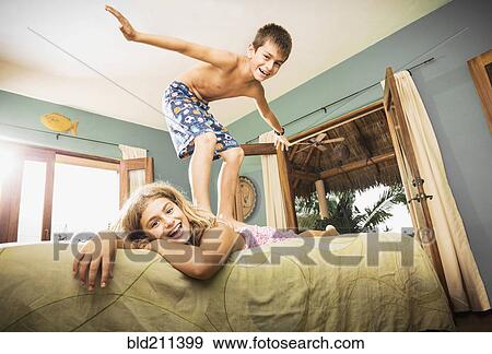 Mixed race children playing on bed View Large Photo Image Stock Photo - Mixed race children playing on bed. Fotosearch