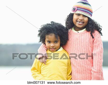 Stock Image - Mixed race children posing outdoors. Fotosearch