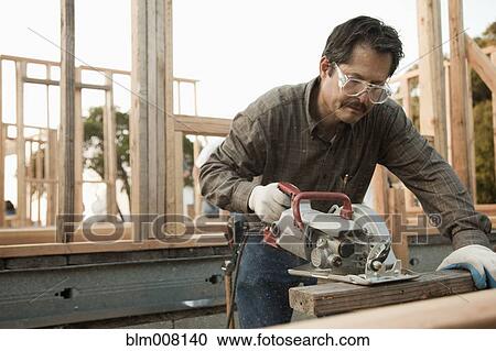 Mixed race construction worker using saw on lumber View Large Photo Image Stock Image - Mixed race construction worker using saw on lumber. Fotosearch