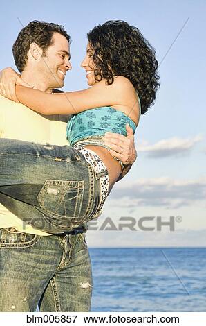 Mixed race couple playing on beach View Large Photo Image Stock Photo - Mixed race couple playing on beach. Fotosearch