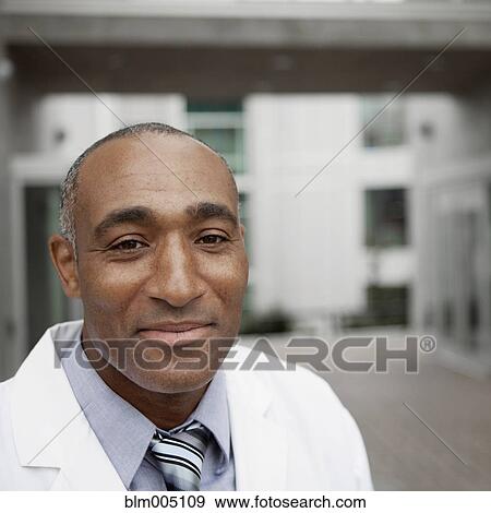 Stock Photo - Mixed race doctor standing outdoors. Fotosearch