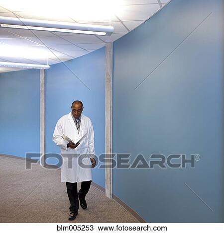 Mixed race doctor walking in hospital with medical chart View Large Photo Image Stock Image - Mixed race doctor walking in hospital with medical chart. Fotosearch