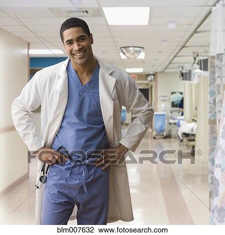 Stock Image - Mixed race doctor wearing scrubs in hospital. Fotosearch