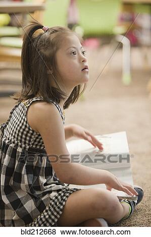 Mixed race Down syndrome student sitting on floor View Large Photo Image Stock Photo - Mixed race Down syndrome student sitting on floor. Fotosearch
