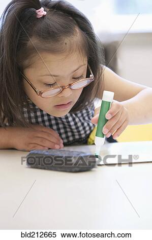Stock Photography - Mixed race Down syndrome student drawing in class. Fotosearch